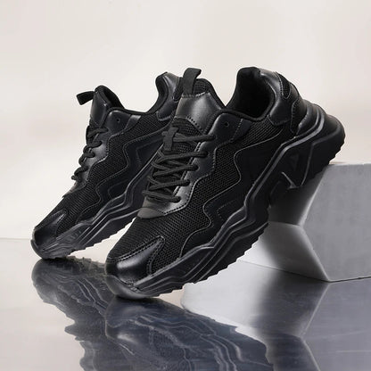 Black chunky mesh lace-up sneakers for women with textured sole, displayed on gray blocks against neutral background