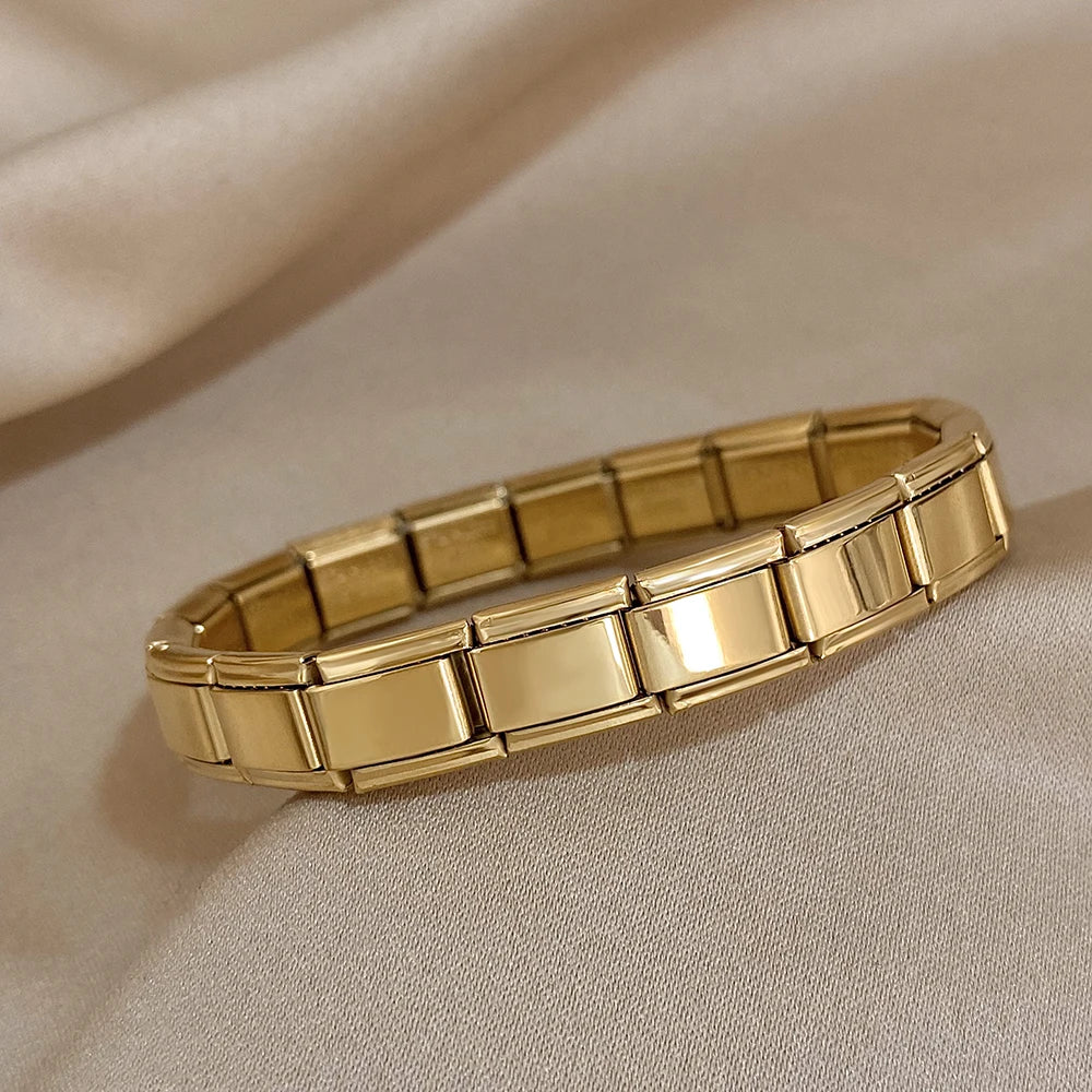 Gold interlocking link chain bracelet for women with flexible stretch design on beige fabric background