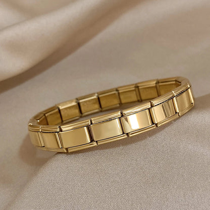 Gold interlocking link chain bracelet for women with flexible stretch design on beige fabric background