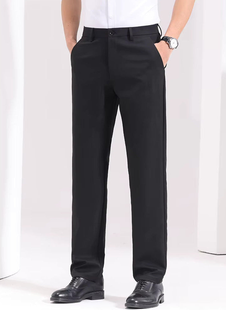 Man wearing black slim-fit cotton dress trousers with white shirt and black oxford shoes, front view showing straight leg cut.
