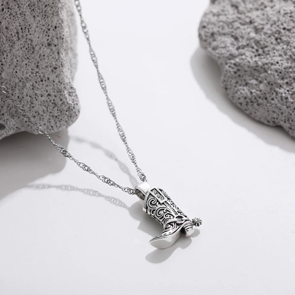 Silver necklace with intricate filigree western cowboy boot charm pendant on delicate twisted chain