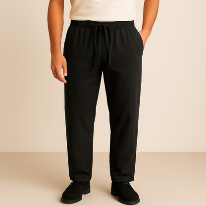 Man wearing black linen-cotton drawstring pants with elastic waistband, paired with a white tee and black shoes.