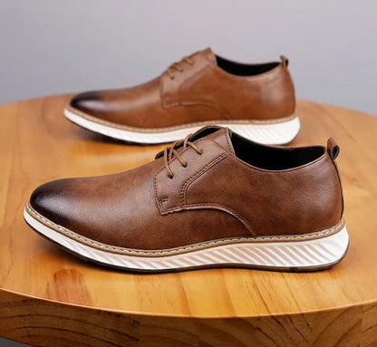 Brown leather Torino Orthopedic Sneakers with white striped soles and lace-up closure displayed on wooden surface