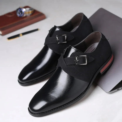 Black leather and suede men's dress loafers with double monk strap buckles and red-accented sole displayed on white surface