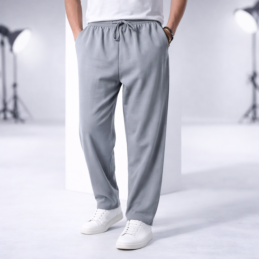 Man wearing light gray cotton drawstring pants with side pockets, paired with white sneakers and a white t-shirt.