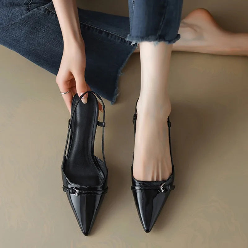 Black pointed-toe slingback block heel pumps with patent leather trim and buckle detail for women