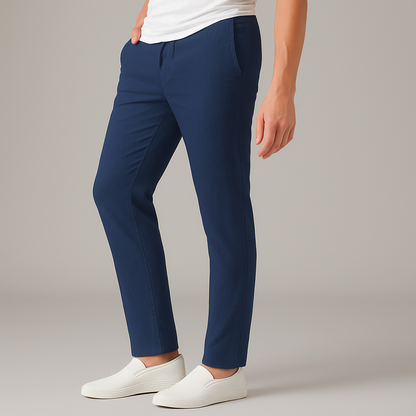 Man wearing navy blue slim-fit Verdan drawstring linen pants with white t-shirt and white slip-on sneakers