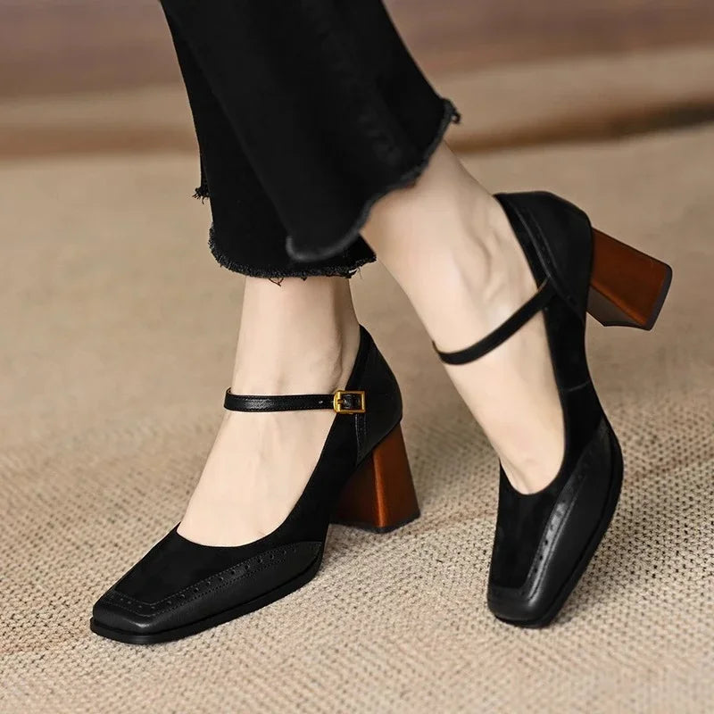 Black square toe leather block heel pumps with ankle strap buckle closure and wooden-style chunky heel, worn with black jeans
