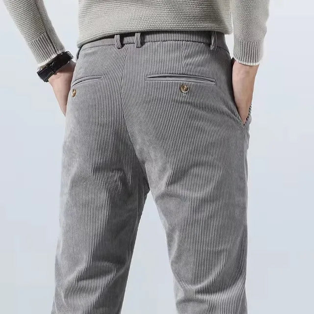 Men's gray corduroy slim fit chino pants back view showing welt pocket with button detail and belt loops.