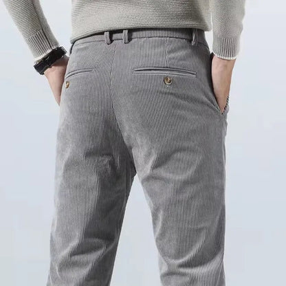 Men's gray corduroy slim fit chino pants back view showing welt pocket with button detail and belt loops.