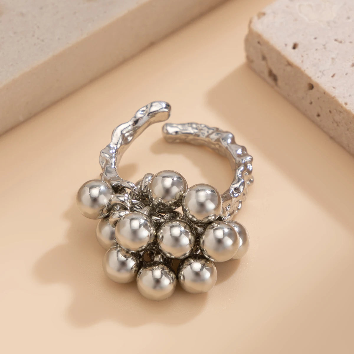 Silver adjustable open-band ring featuring a cluster of polished metallic spherical beads on a textured band.
