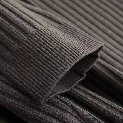 Close-up of dark brown ribbed knit fabric texture showing fine vertical ribbing detail on a men's quarter-zip sweater.