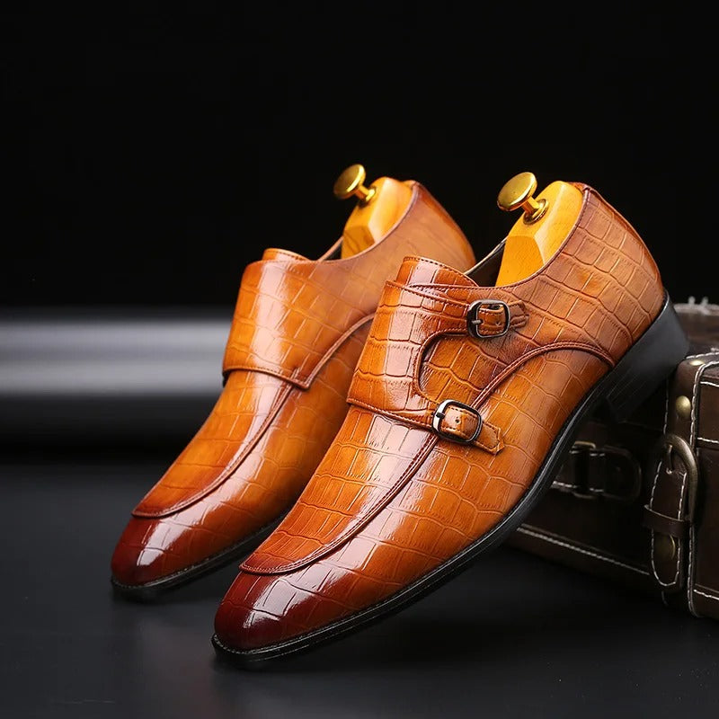 Men's brown crocodile embossed leather double monk strap dress shoes with wooden shoe trees on black background
