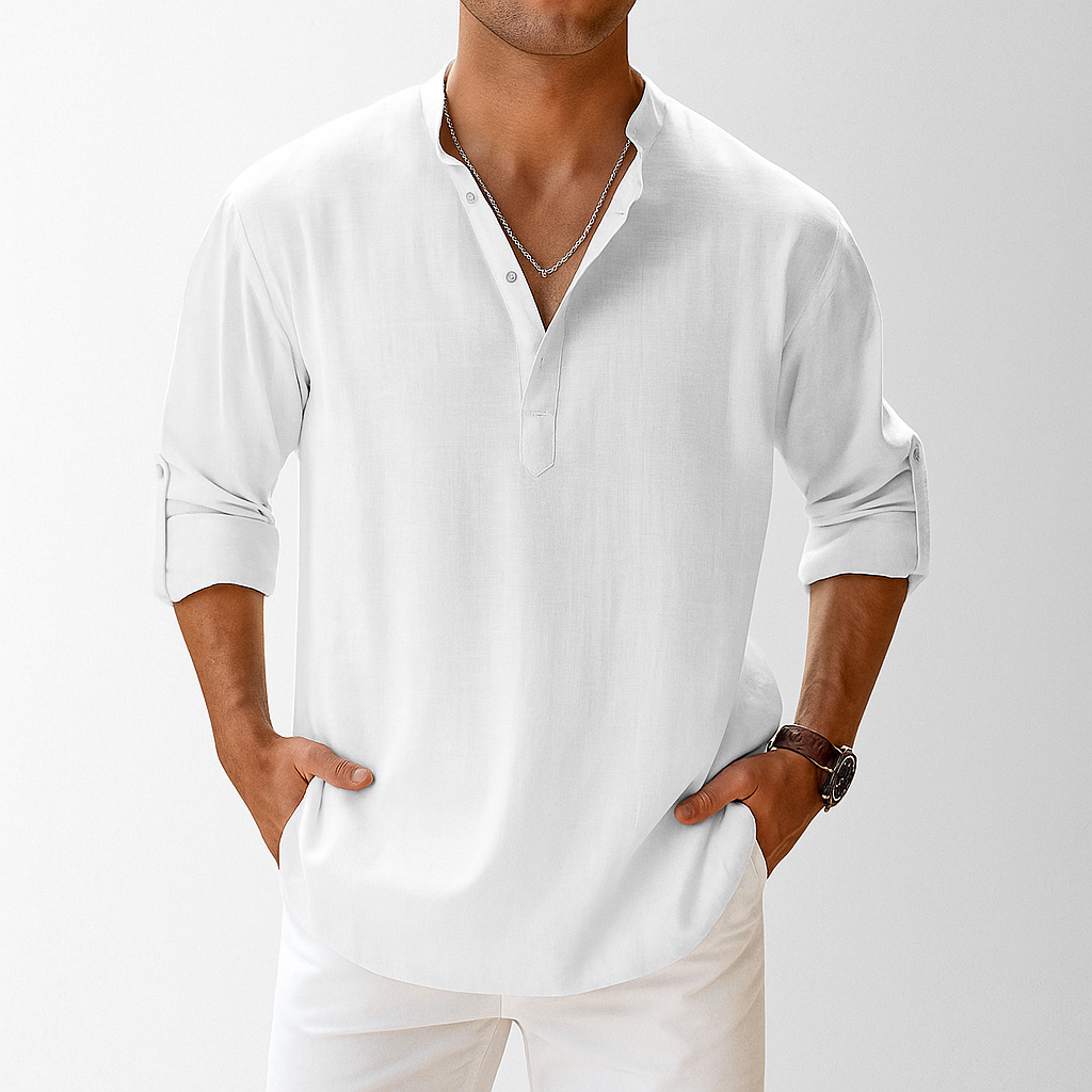 Man wearing white linen popover henley shirt with rolled sleeves, paired with white pants and a silver chain necklace.