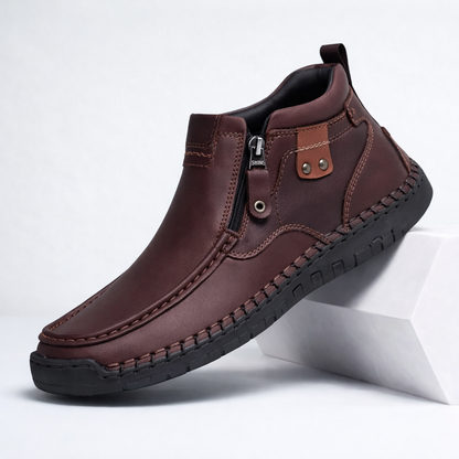 Dark brown men's leather ankle boots with side zipper, decorative stitching, metal rivets, and black rubber sole.