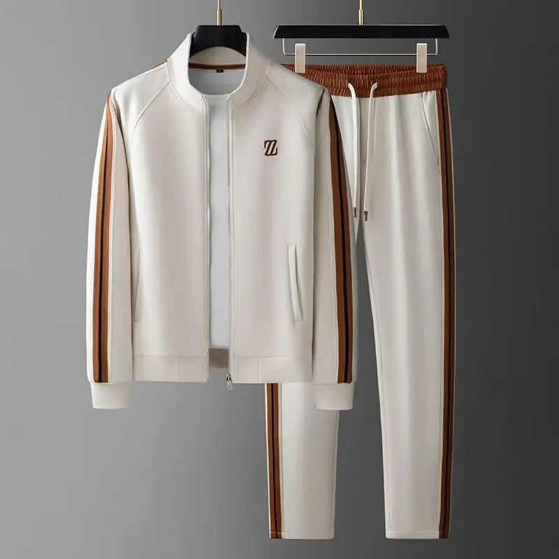 White men's zip-up tracksuit set with brown leather side stripes, stand collar jacket and drawstring jogger pants.