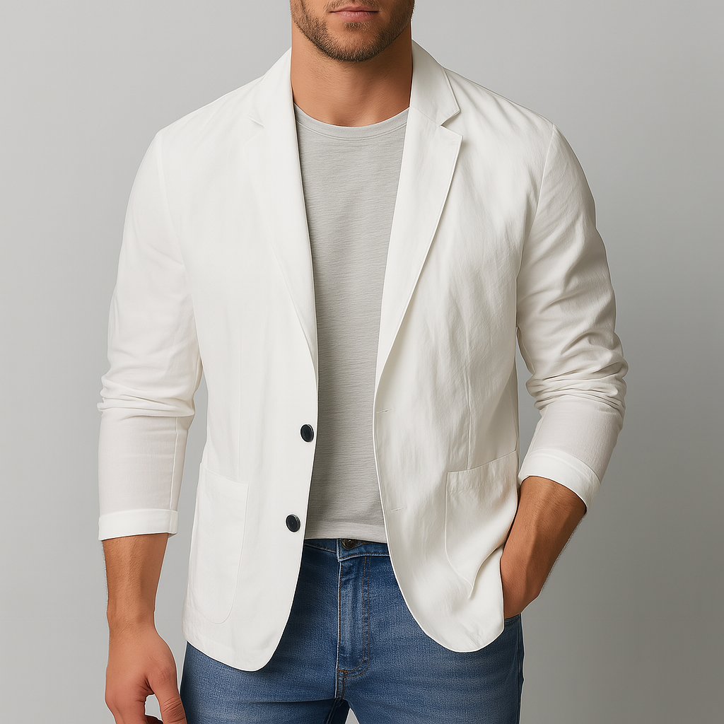 Man wearing an open white nylon two-button blazer over a gray tee with blue jeans, sleeves casually rolled up.