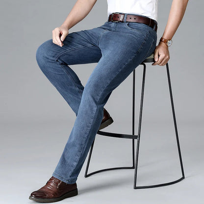 Men's blue stretch slim-fit denim jeans with brown leather belt and dress shoes business casual style