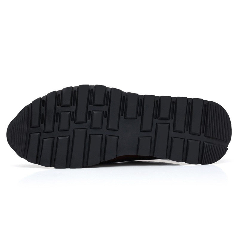Bottom view of men's leather slip-on loafers showing black rubber outsole with rectangular tread pattern for grip and durability.