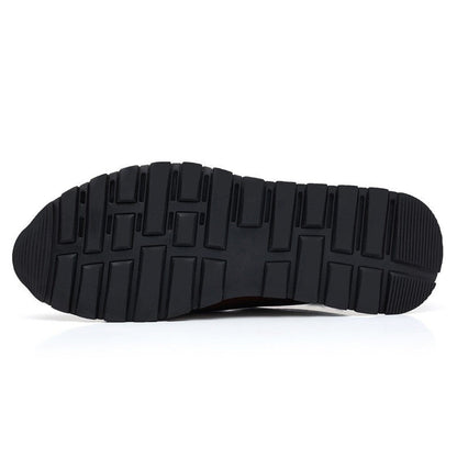 Bottom view of men's leather slip-on loafers showing black rubber outsole with rectangular tread pattern for grip and durability.