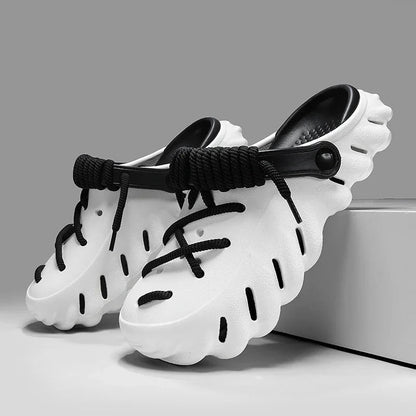 White and black cushioned foam clog shoes with lace-up design, ventilation holes, and adjustable heel strap for men