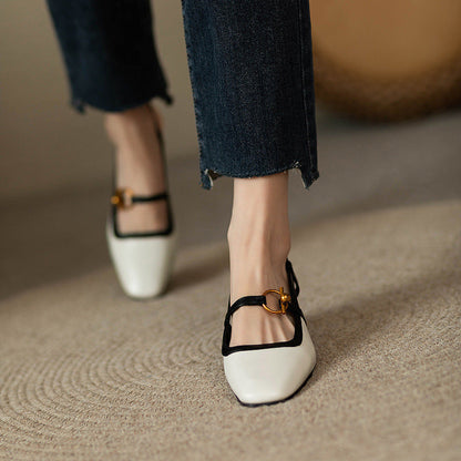 Women's ivory leather block heel pumps with black trim and gold buckle strap, paired with cropped dark jeans.