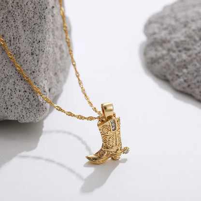 Gold necklace with ornate Western cowboy boot charm pendant featuring scroll details and crystal accents on twisted chain