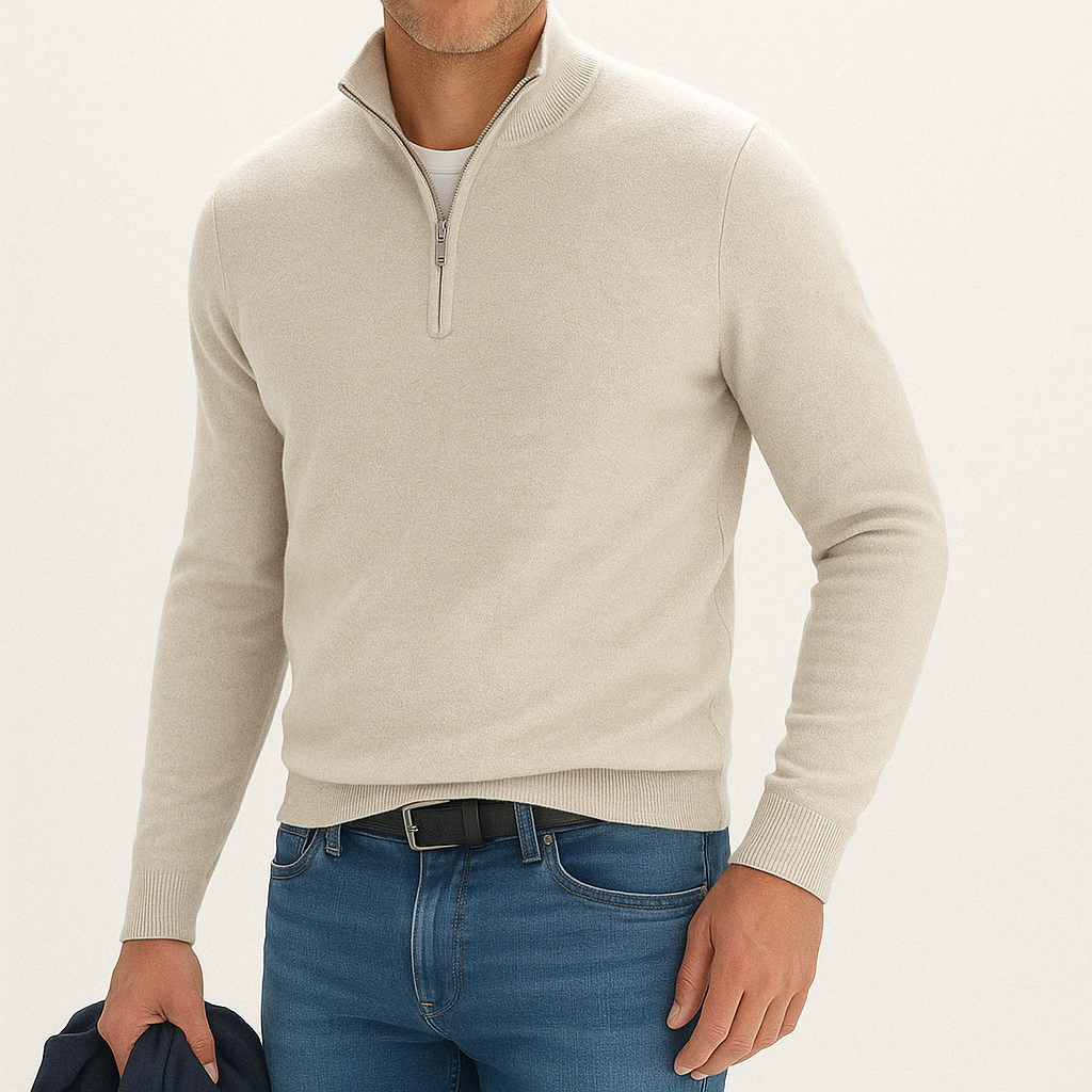 Men's beige cashmere blend quarter-zip sweater with ribbed cuffs and hem, styled with blue jeans and white t-shirt underneath.