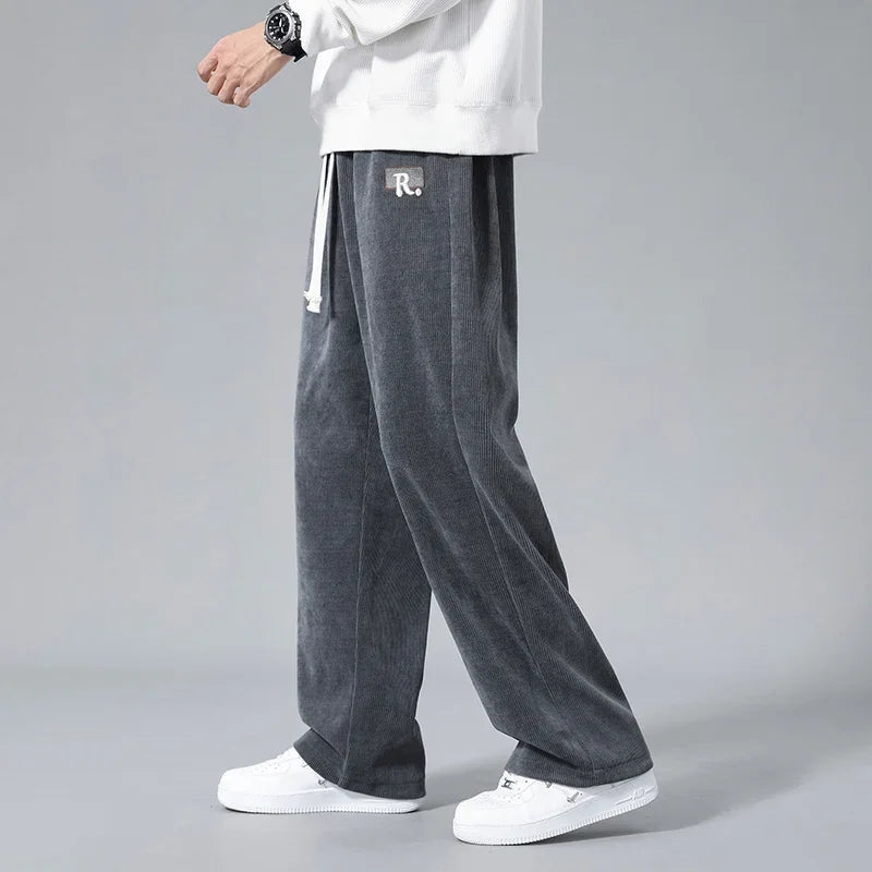Men's wide-leg gray corduroy drawstring sweatpants with R. logo patch, paired with white sneakers and sweatshirt