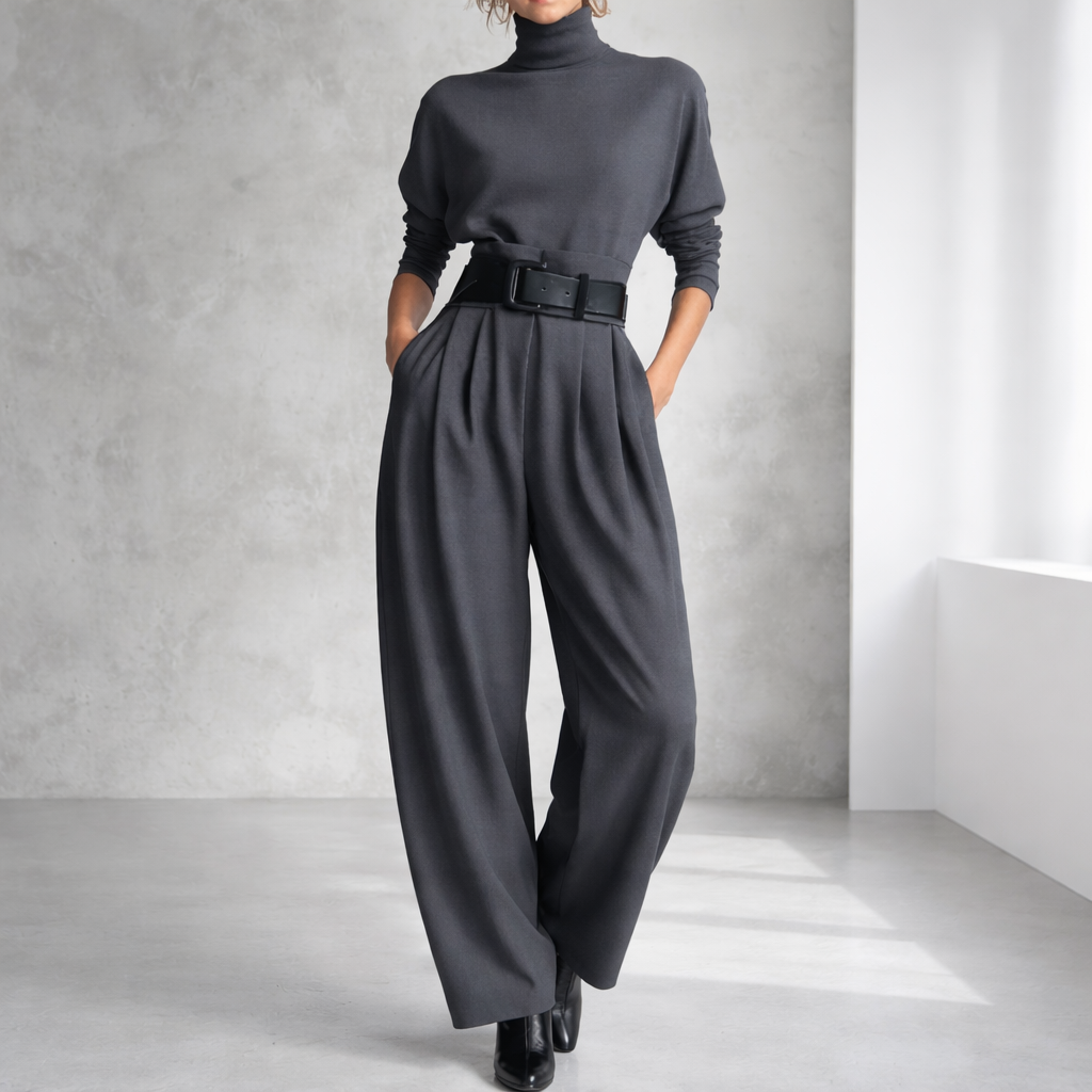 Women's charcoal gray turtleneck top and wide-leg pleated pants set with black belt and black ankle boots.