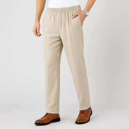 Man wearing beige linen drawstring pants with elastic waist, paired with brown leather dress shoes and a silver watch.
