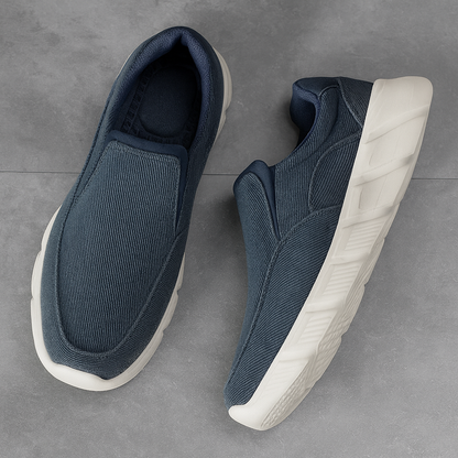 Navy blue corduroy slip-on sneakers for men with white textured sole, shown as a pair on gray background.