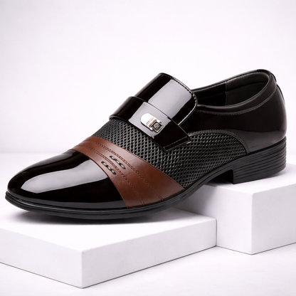 Torreno men's black patent leather slip-on loafers with brown accent stripe and silver metal buckle detail on white display block