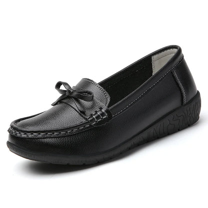 Black women's leather slip-on loafers with decorative bow detail and textured rubber sole on white background
