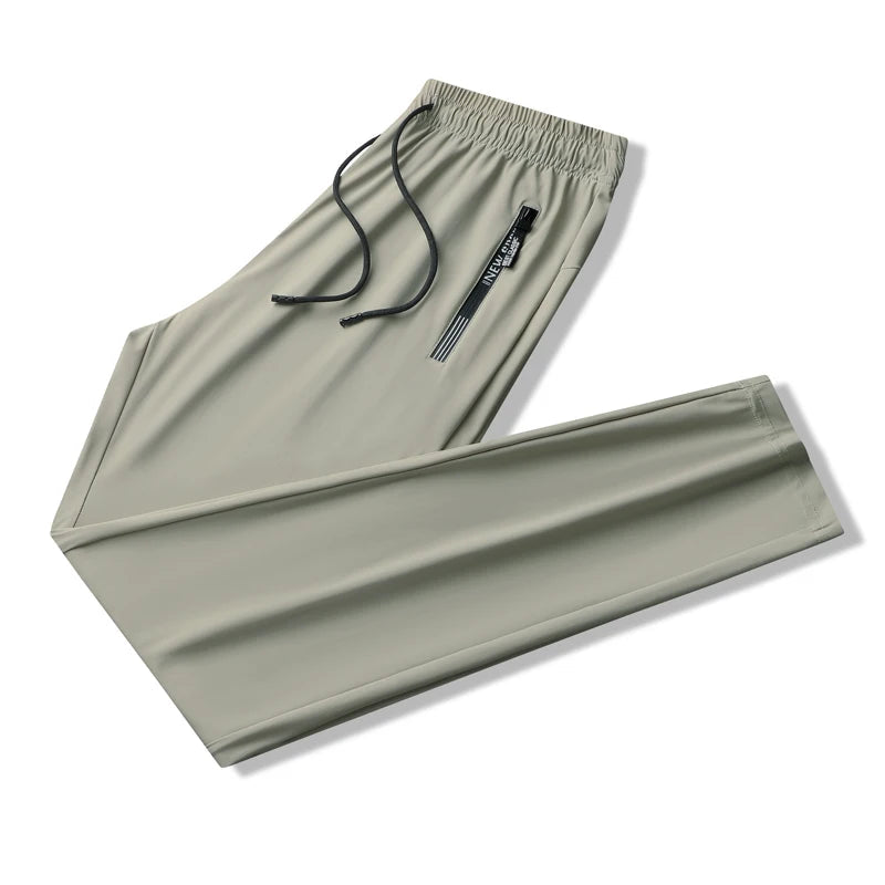 Light green men's stretch sweatpants with elastic drawstring waist and side zip pocket, folded flat view.