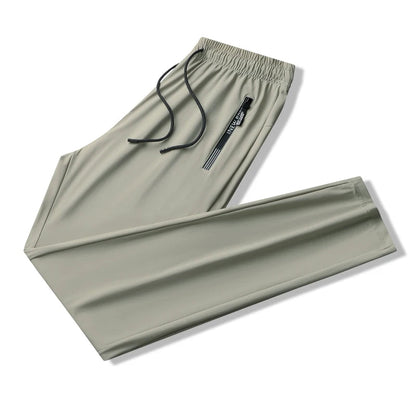 Light green men's stretch sweatpants with elastic drawstring waist and side zip pocket, folded flat view.
