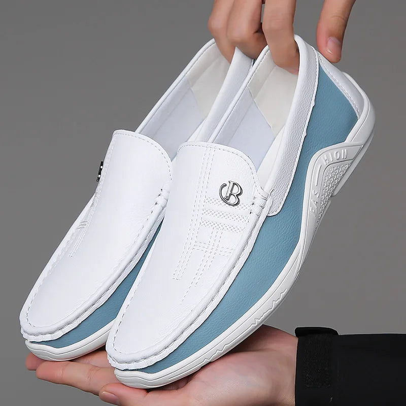 White and blue leather slip-on loafers for men with metal logo detail and stitched upper, held by two hands