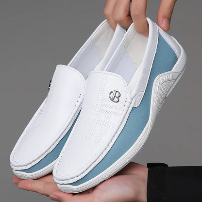 White and blue leather slip-on loafers for men with metal logo detail and stitched upper, held by two hands
