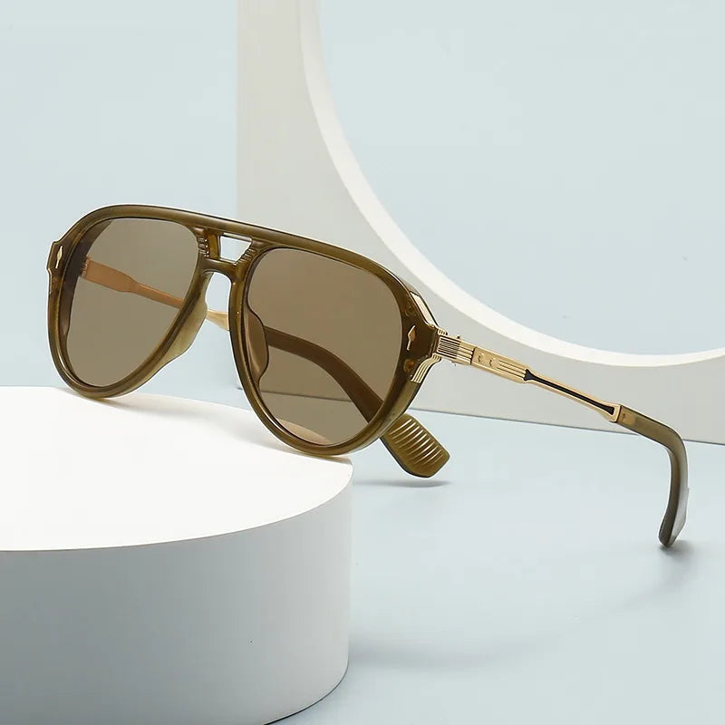 Olive green aviator sunglasses with gold metal temples and brown gradient lenses displayed on white pedestals
