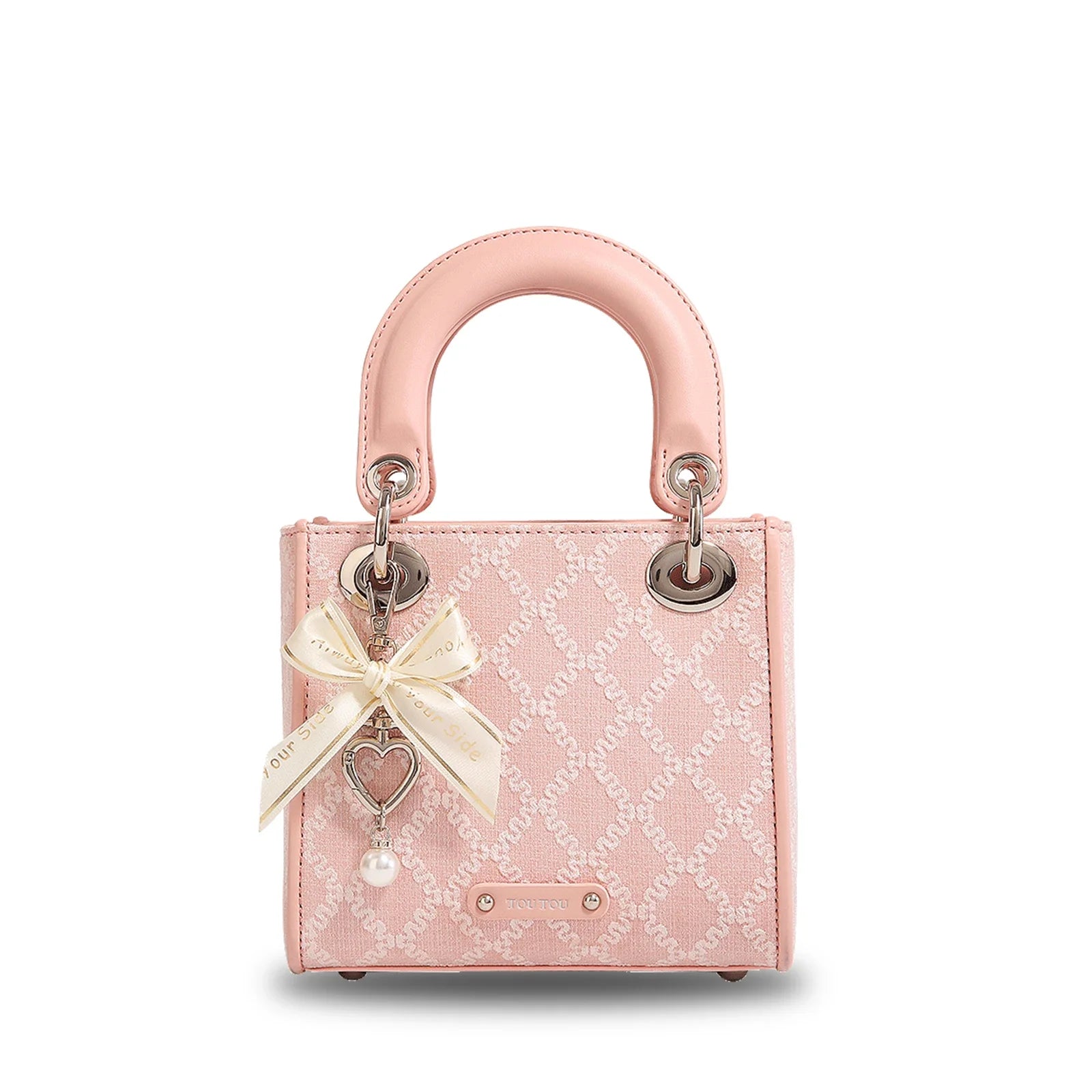 Pink jacquard mini handbag with bow charm, pearl drop, heart pendant, structured top handle, and gold-tone hardware.