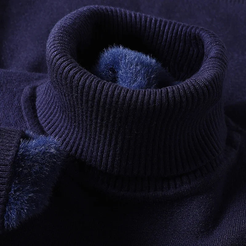 Navy blue men's merino wool turtleneck sweater with ribbed collar and soft fleece interior lining detail.