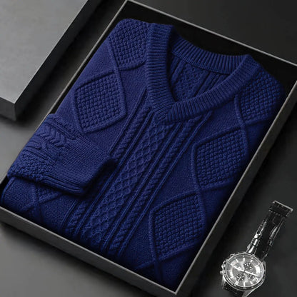 Navy blue cable knit v-neck wool sweater for men, neatly folded in gift box with watch beside it.
