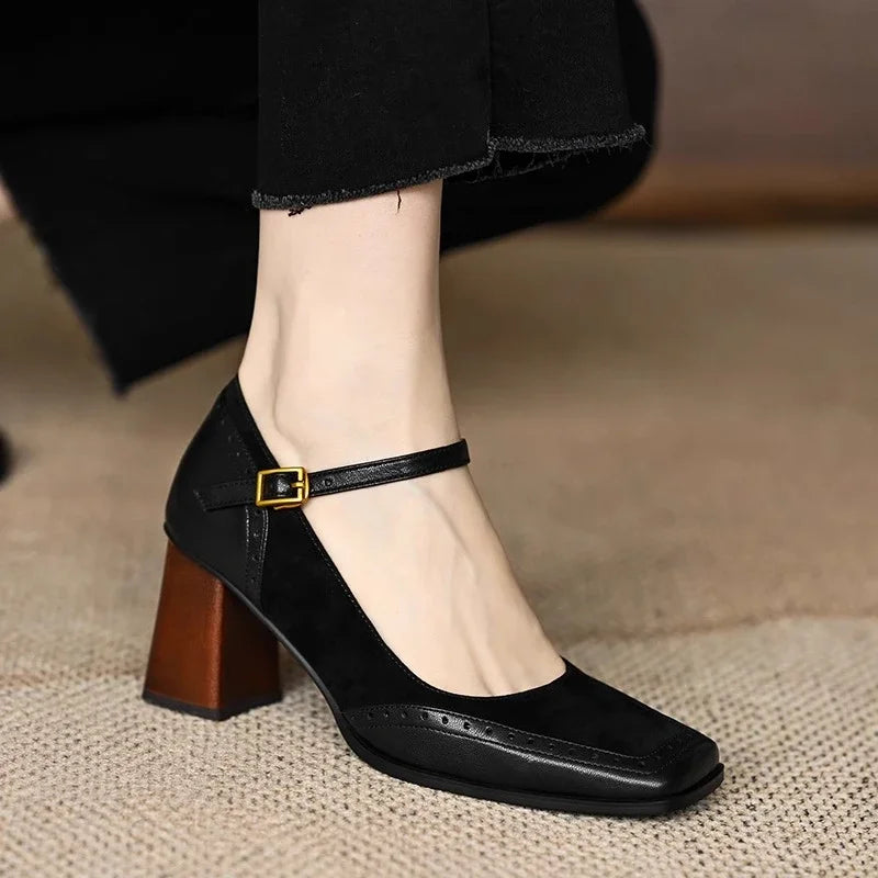 Black women's square toe leather block heel pumps with ankle strap buckle and brogue detailing worn with black trousers