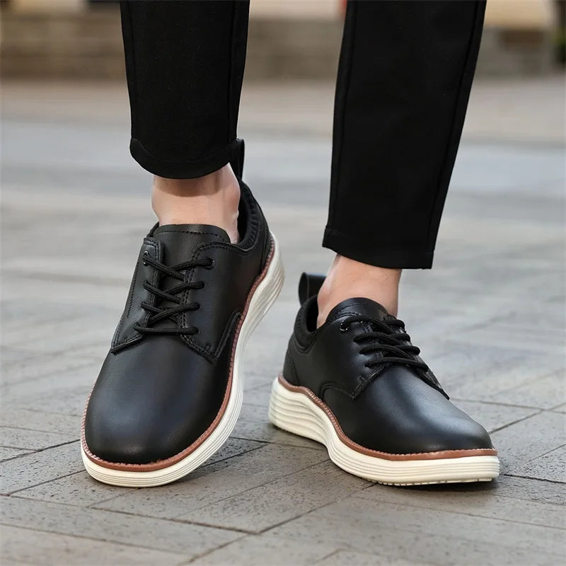 Black leather lace-up casual men's shoes with white chunky sole, worn with black trousers on cobblestone surface