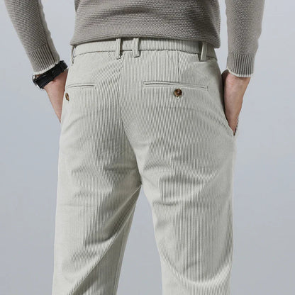 Light beige men's slim fit corduroy pants shown from behind, featuring back pockets with gold buttons and belt loops.