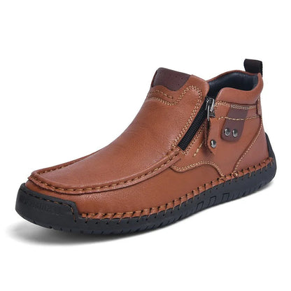 Brown leather men's ankle boots with side zipper, hand-stitched detailing, and rubber sole on white background