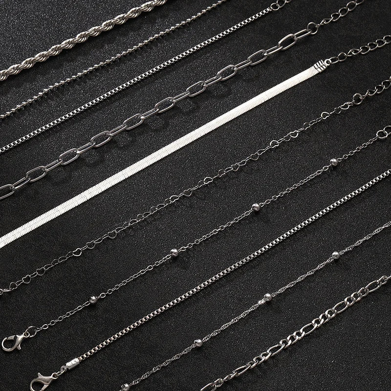 Set of 8 silver stainless steel chain bracelets in various styles including rope, box, herringbone, and link chains