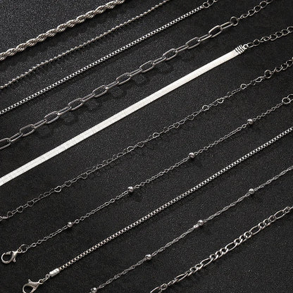 Set of 8 silver stainless steel chain bracelets in various styles including rope, box, herringbone, and link chains