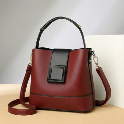 Burgundy and black leather bucket handbag with top handle, adjustable shoulder strap, and gold hardware for women