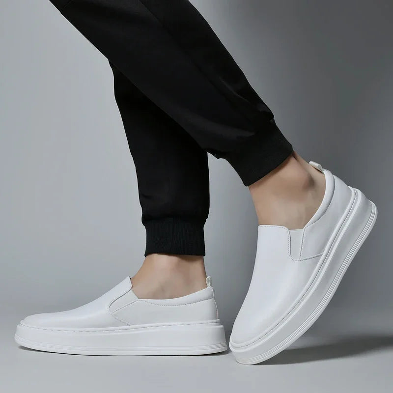 White leather slip-on sneakers for men with elastic gores and platform sole worn with black joggers